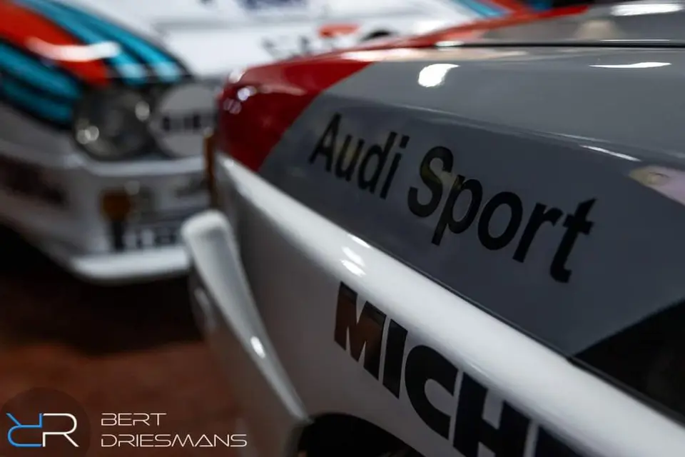 Detail van een Audi Sport-wagen naast een Lancia in Martini-kleuren